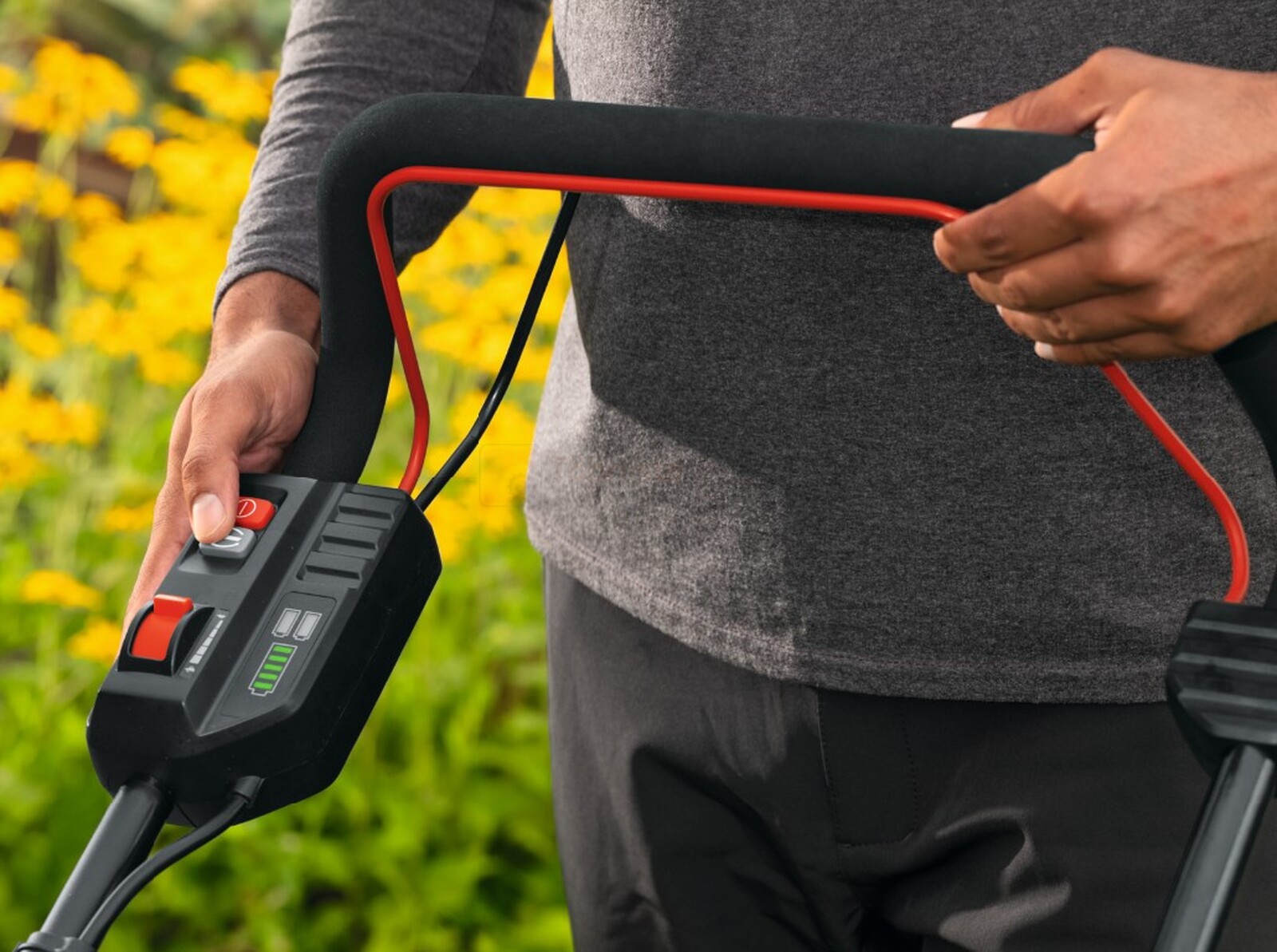 Pildil on näha inimest, kes hoiab käes Bosch akumuruniiduki GRA 18V2-46 SP käepidet, mis sisaldab juhtnuppe ja akulaetuse...